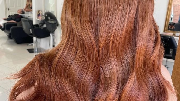 Rich copper hair in soft waves, coloured in the salon.