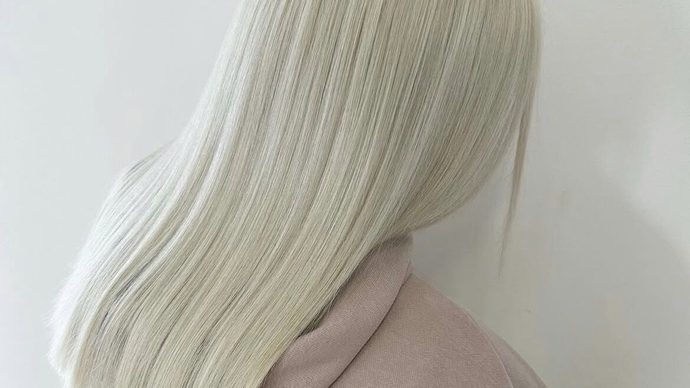 Sleek platinum blonde hair, freshly coloured and straightened.