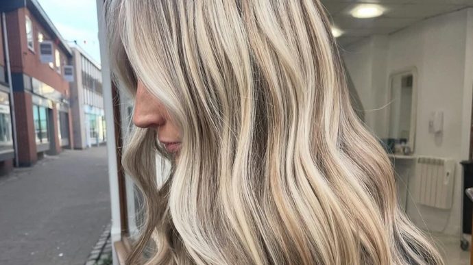 Blonde highlights with soft waves, by the salon window on Church Gate.